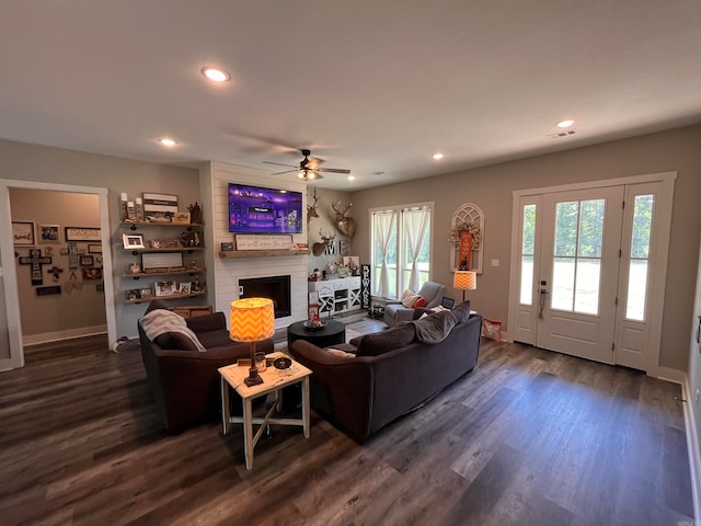 living room with ceiling fan, a fireplace, and dark hardwood / wood-style flooring