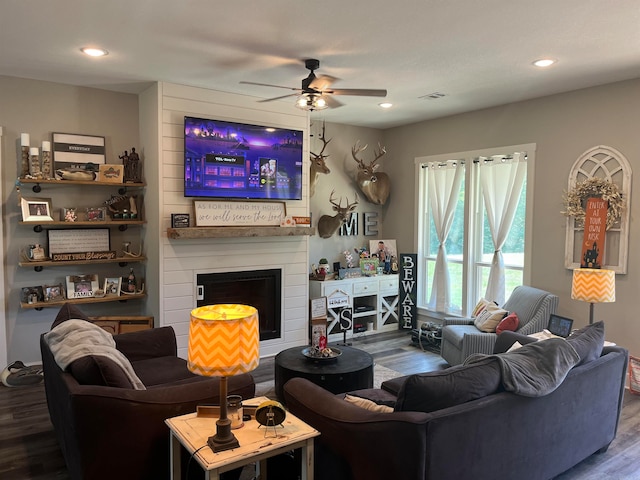 living room with ceiling fan, hardwood / wood-style flooring, and a fireplace