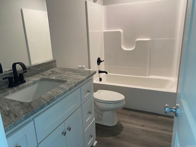 full bathroom featuring hardwood / wood-style floors, tub / shower combination, toilet, and vanity