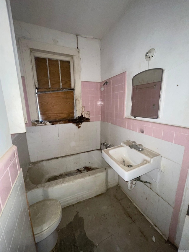 bathroom featuring sink, toilet, and tile walls