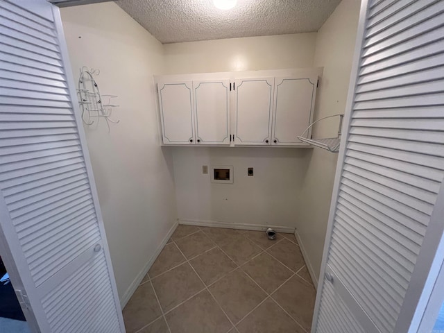 washroom featuring tile patterned flooring, cabinets, hookup for an electric dryer, hookup for a washing machine, and a textured ceiling