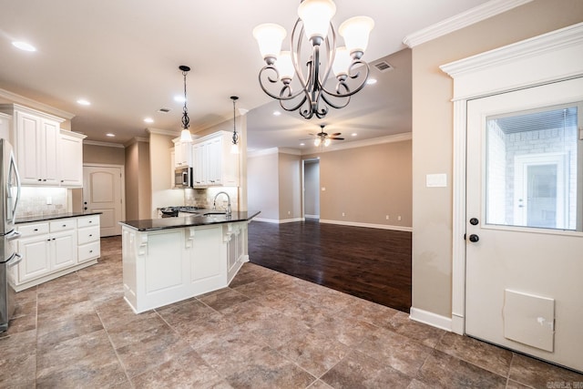 kitchen featuring tasteful backsplash, decorative light fixtures, and white cabinets