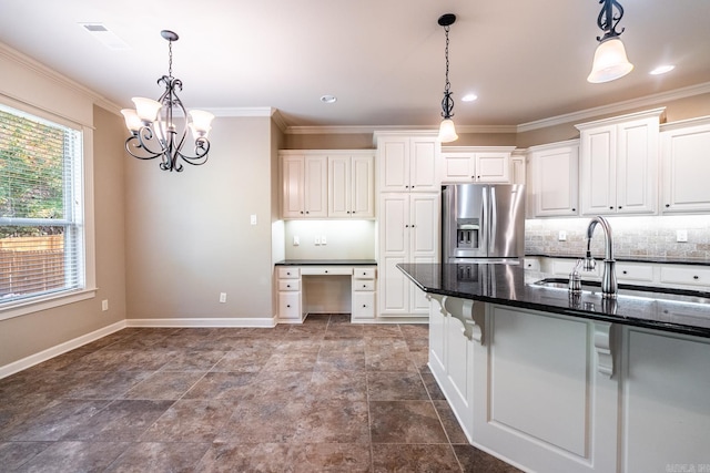 kitchen featuring white cabinets, dark stone countertops, sink, hanging light fixtures, and stainless steel refrigerator with ice dispenser