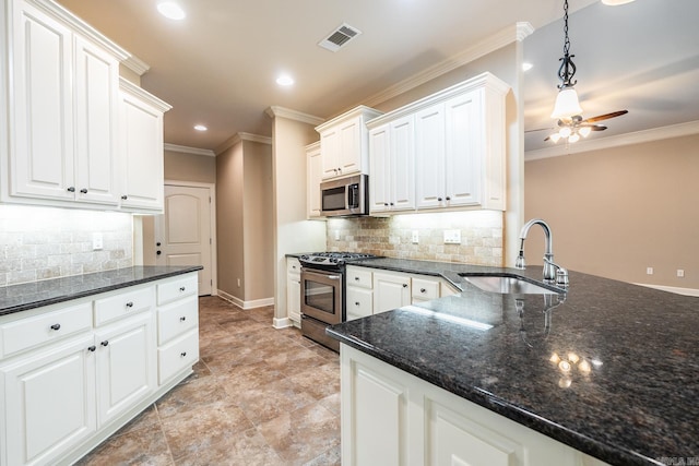 kitchen with white cabinets, appliances with stainless steel finishes, sink, and decorative backsplash