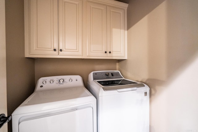 washroom featuring cabinets and washer and clothes dryer