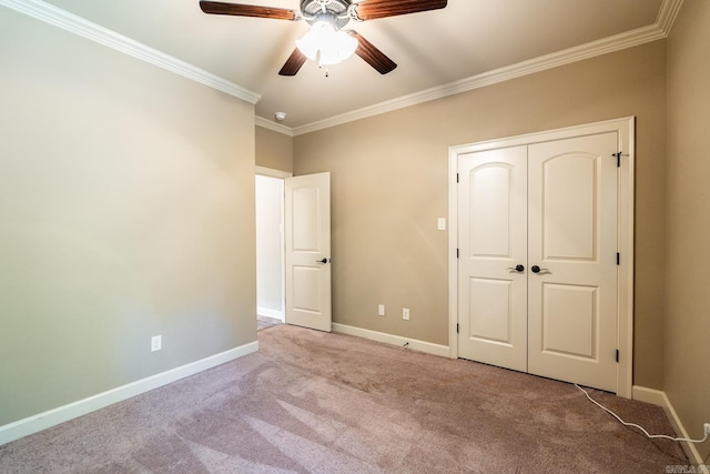 unfurnished bedroom featuring a closet, crown molding, light colored carpet, and ceiling fan