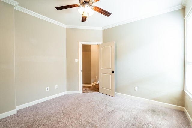 spare room featuring ornamental molding, a healthy amount of sunlight, ceiling fan, and light colored carpet