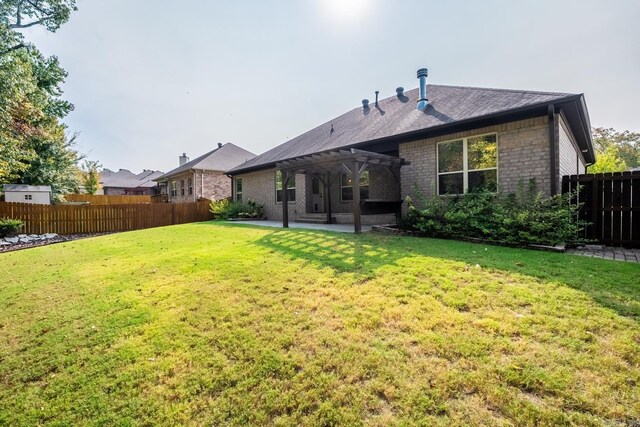 rear view of property with a pergola, a patio, and a lawn