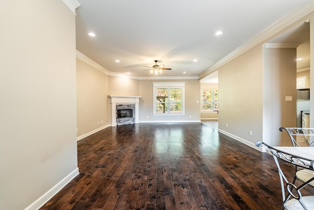 unfurnished living room with crown molding, ceiling fan, and dark hardwood / wood-style floors