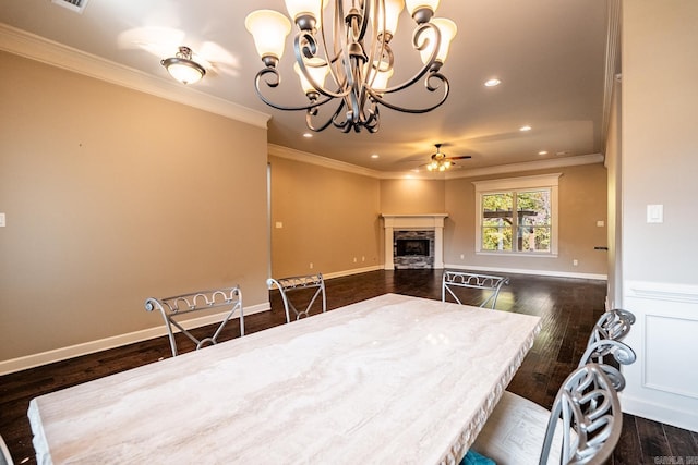 dining area featuring ceiling fan with notable chandelier, crown molding, and dark wood-type flooring