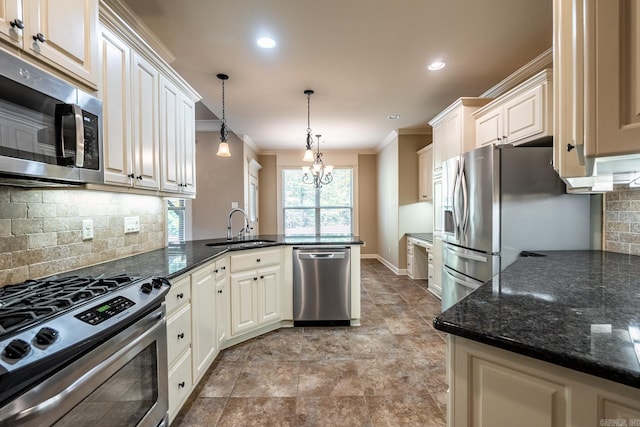 kitchen featuring crown molding, decorative light fixtures, sink, stainless steel appliances, and kitchen peninsula