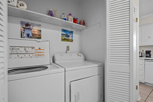 clothes washing area with crown molding, light tile patterned floors, and washer and clothes dryer