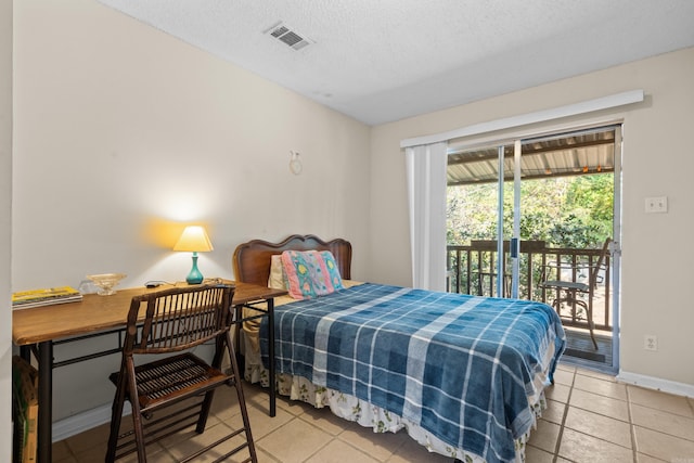 bedroom with access to outside, light tile patterned flooring, and a textured ceiling