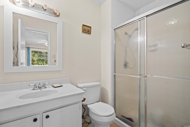 bathroom featuring vanity, toilet, a shower with shower door, and a textured ceiling