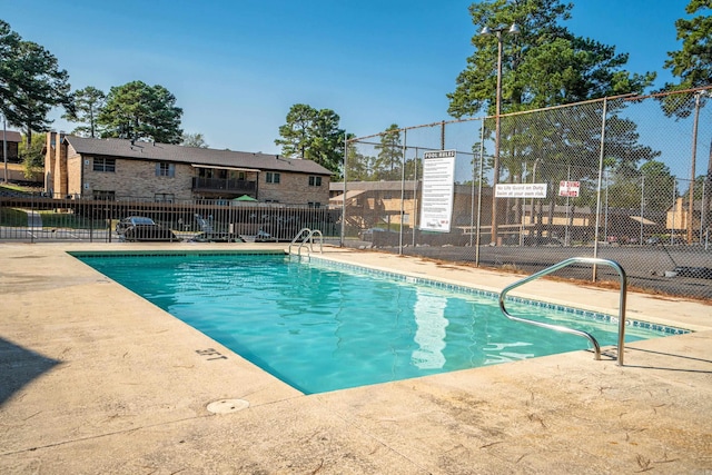 community pool featuring a patio area and fence