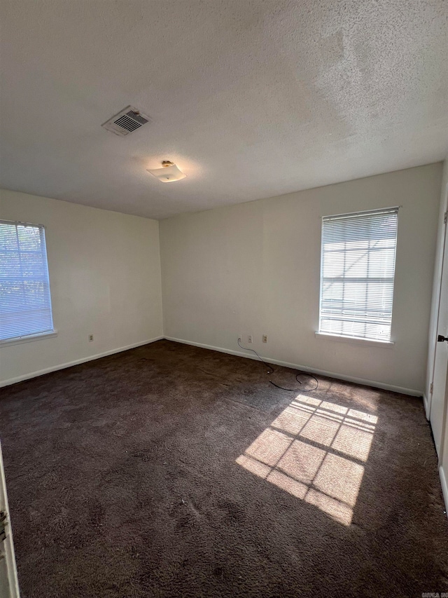 carpeted spare room featuring a textured ceiling