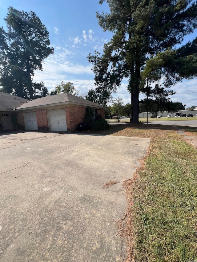 view of side of property with a lawn and a garage