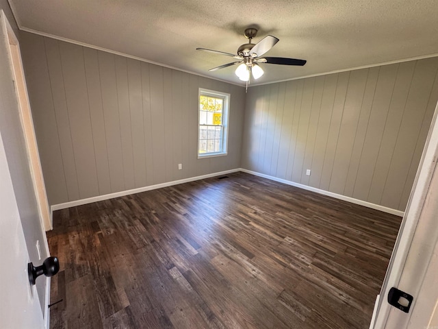 unfurnished room with a textured ceiling, dark hardwood / wood-style floors, wooden walls, and ceiling fan