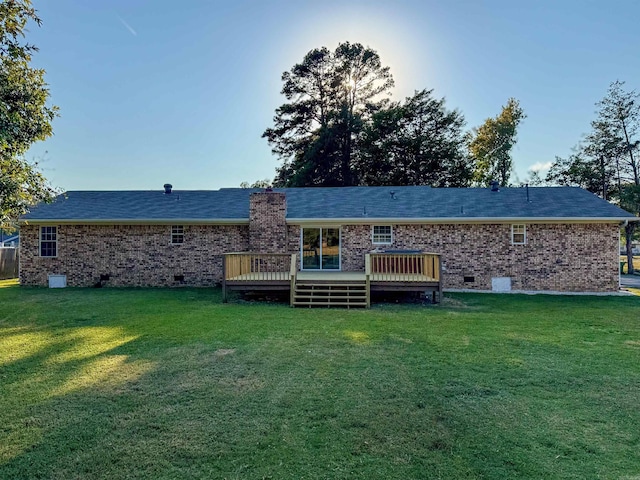 back of property with a lawn and a deck