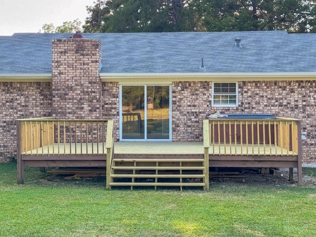 rear view of property featuring a lawn and a deck