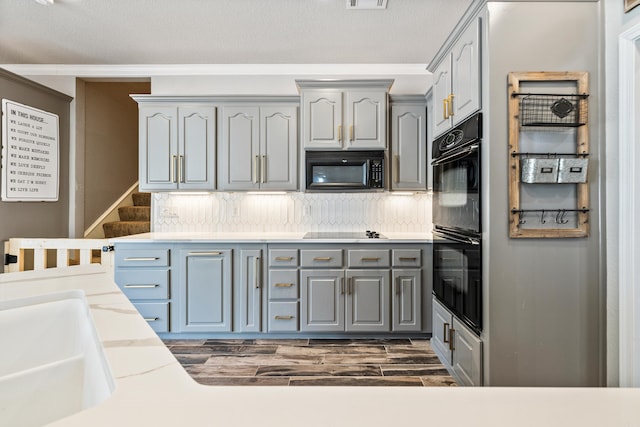 kitchen with gray cabinetry, backsplash, sink, and black appliances