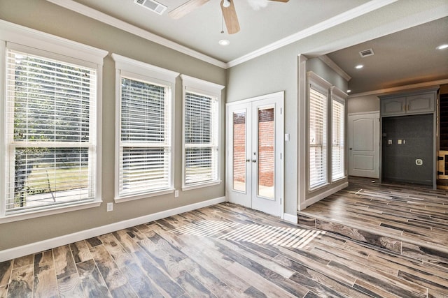 empty room featuring french doors, hardwood / wood-style flooring, crown molding, and ceiling fan