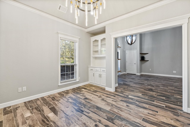 unfurnished dining area featuring dark hardwood / wood-style floors, a chandelier, and crown molding