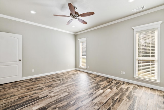 empty room with crown molding, hardwood / wood-style floors, a wealth of natural light, and ceiling fan