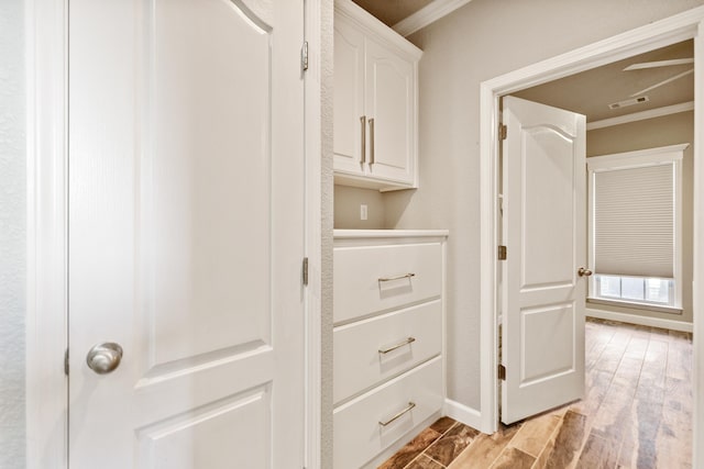 interior space featuring light wood-type flooring and crown molding