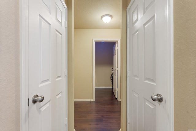 hall featuring dark hardwood / wood-style floors and a textured ceiling