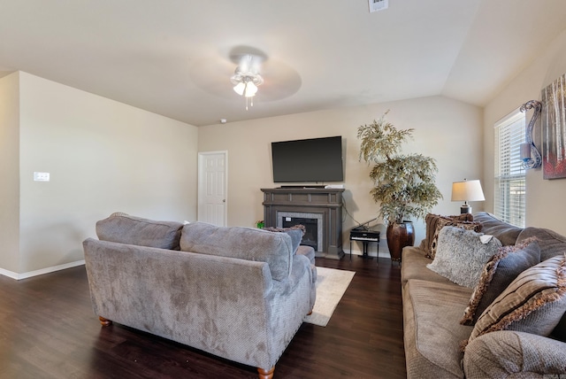 living room featuring ceiling fan, dark hardwood / wood-style floors, and vaulted ceiling