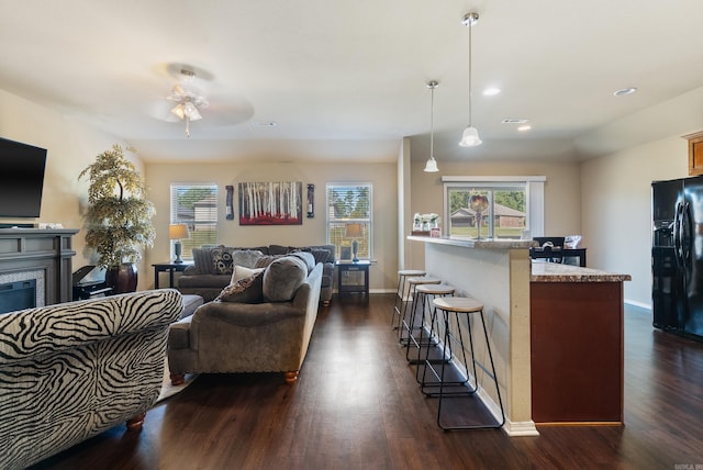 living room with dark wood-type flooring and ceiling fan