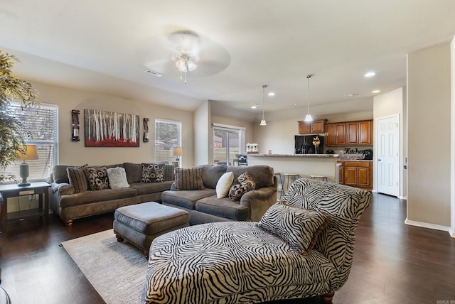 living room featuring ceiling fan and dark hardwood / wood-style floors