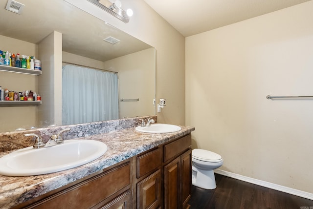 bathroom with hardwood / wood-style flooring, vanity, and toilet