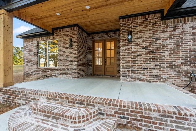 view of exterior entry with a patio area