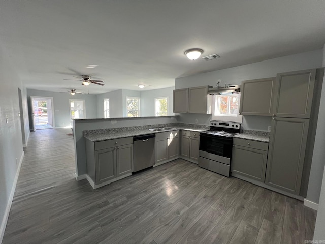 kitchen with dark wood-type flooring, ceiling fan, gray cabinets, appliances with stainless steel finishes, and kitchen peninsula