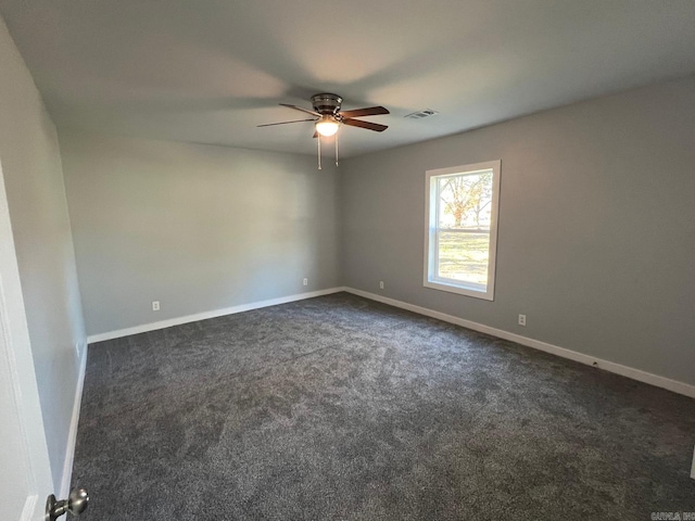 unfurnished room featuring dark colored carpet, ceiling fan, visible vents, and baseboards