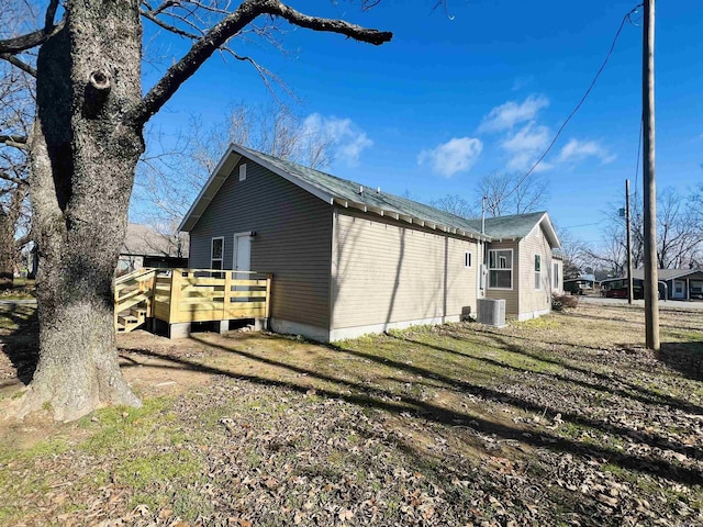 view of property exterior featuring cooling unit and a wooden deck