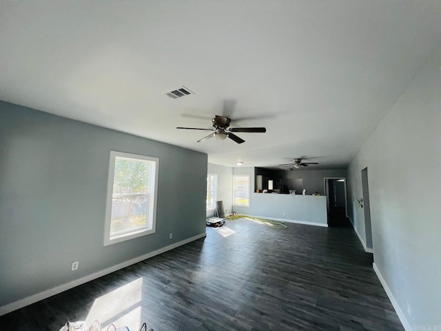 unfurnished living room featuring ceiling fan and dark hardwood / wood-style flooring