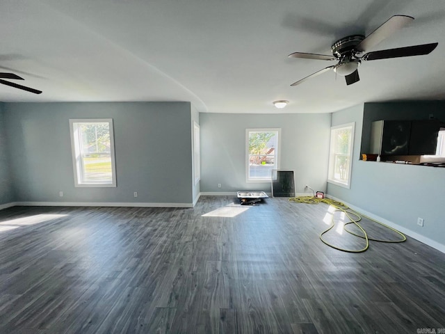 unfurnished living room with ceiling fan, dark hardwood / wood-style flooring, and a wealth of natural light