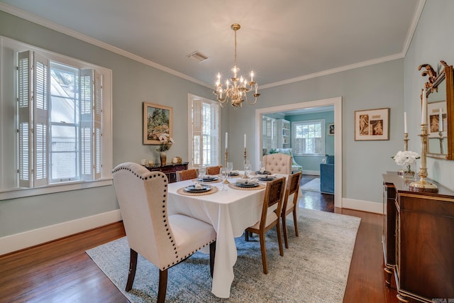 dining space featuring ornamental molding, a chandelier, and dark hardwood / wood-style flooring