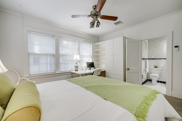 bedroom featuring ceiling fan, crown molding, and ensuite bathroom