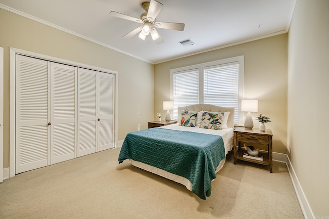 carpeted bedroom featuring ceiling fan, a closet, and crown molding