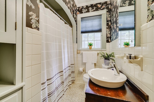 bathroom with a shower with shower curtain, toilet, vanity, and tile walls