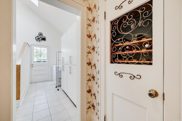 interior space with light tile patterned floors and vaulted ceiling