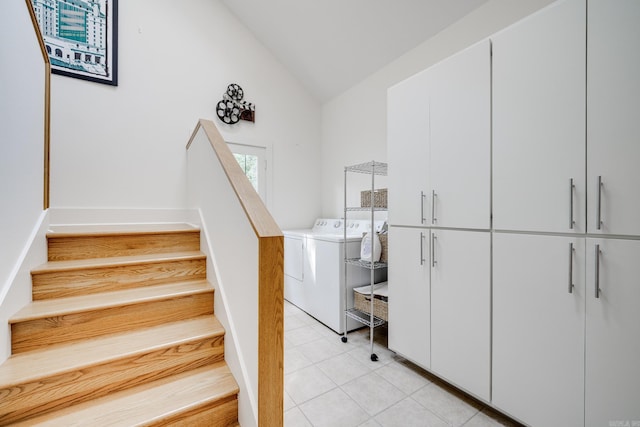 stairway with lofted ceiling, independent washer and dryer, and tile patterned flooring