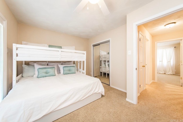 bedroom featuring ceiling fan, light colored carpet, and a closet