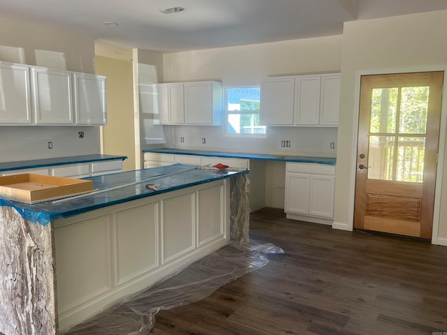 kitchen with a kitchen island, dark wood-type flooring, and white cabinets