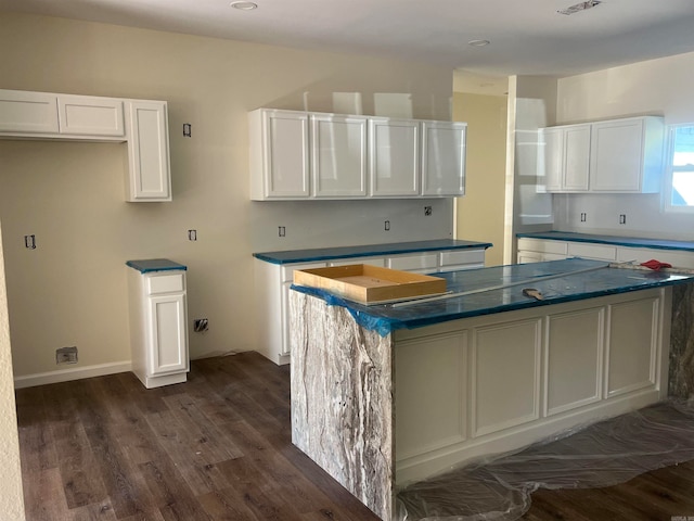 kitchen with white cabinetry, a center island, and dark hardwood / wood-style floors