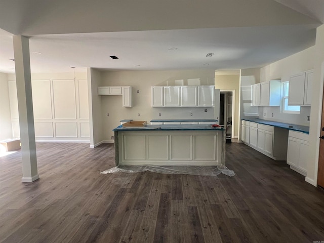 kitchen featuring a center island, dark wood-type flooring, and white cabinets